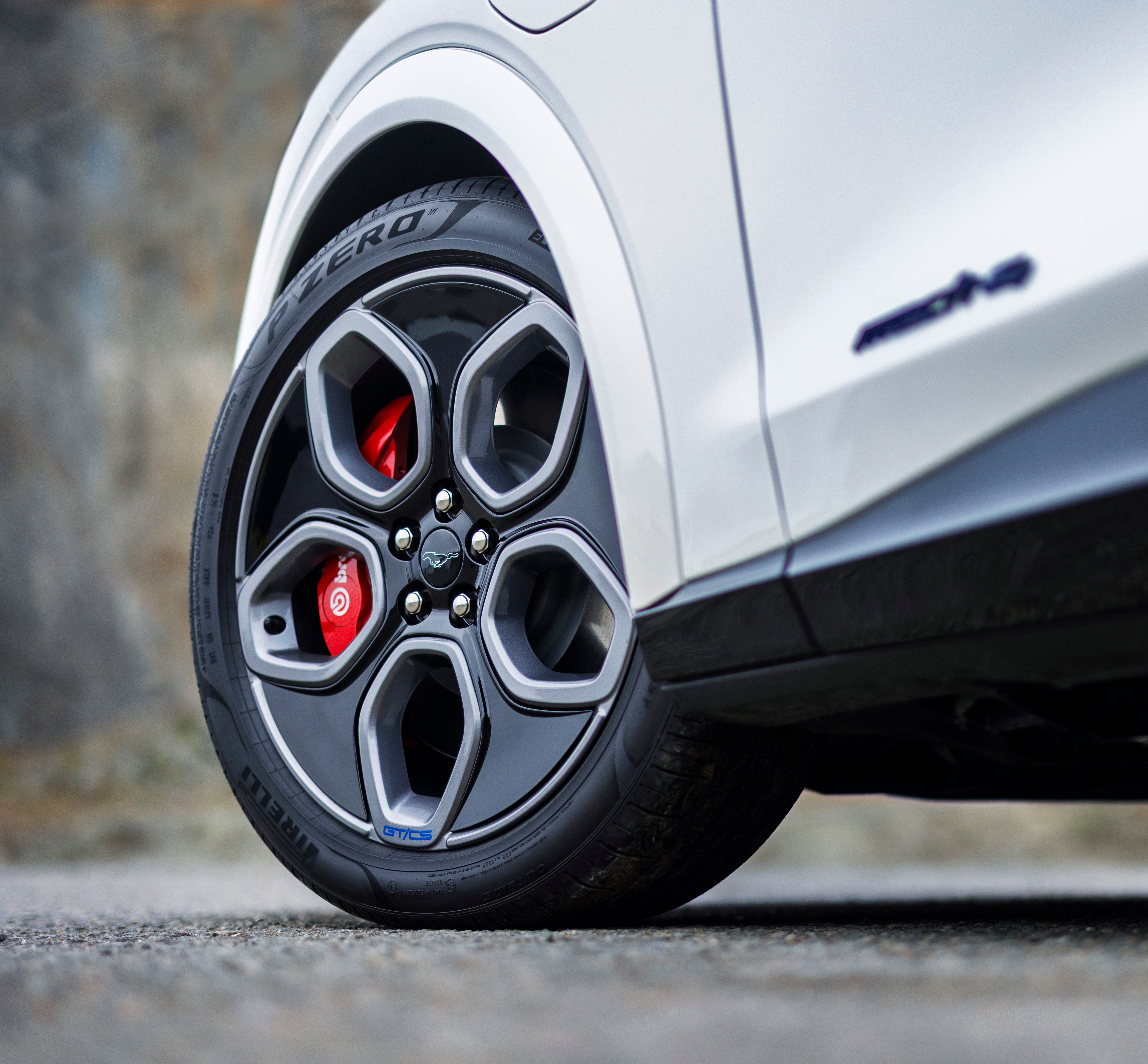 Close-up of a Mustang Mach-E tyre shows a blue Mustang logo in the center.